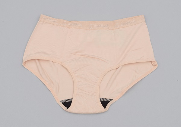 A pair of beige coloured underwear with a black padded gusset designed to absorb period blood.